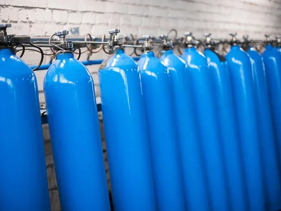 Cilindros de gas azul alineados para uso industrial.